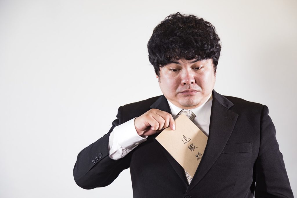 退職届を持つ男性